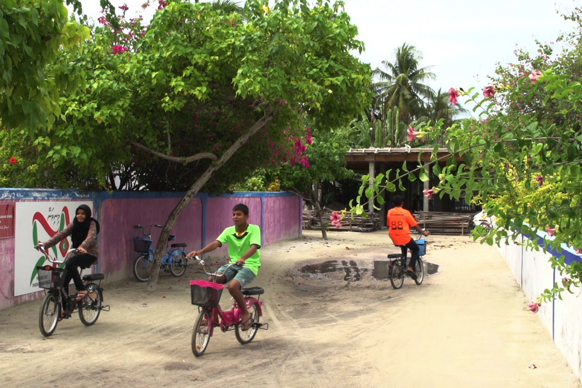 Boutique Beach Maldives Local Children riding bicycles on the island